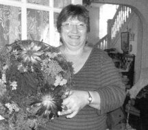 Linda is pictured here holding the living wreath she displayed at a recent meeting